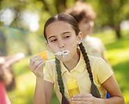 girl-making-soap-bubbles-in-park.jpg